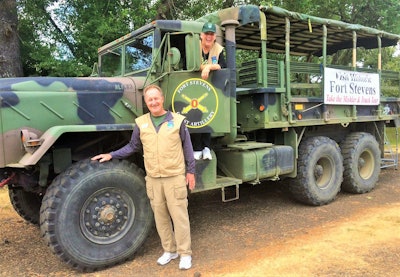 George and Diana Ruelens having picture taken outside of military truck