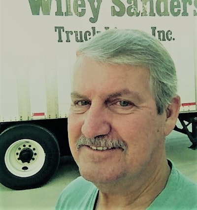 Retired hauler Bob Miller, pictured several years ago with a trailer of the fleet he spent much of his career with, Wiley Sanders.