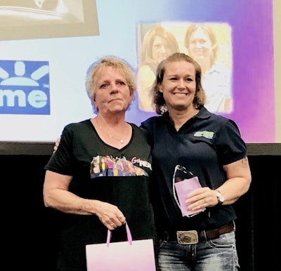 Trucker Elizabeth Sweet (pictured, right) accepting a special Queen of the Road award during Real Women in Trucking’s Saturday, Aug. 24, ceremony at GATS. She is pictured with award presenter Michelle Scolari, among award honorees in the current earlier-year round of this year’s Queen of the Road program. Read more about Scolari and fellow earlier honorees Audrey White and Ramona Hogue via this link.