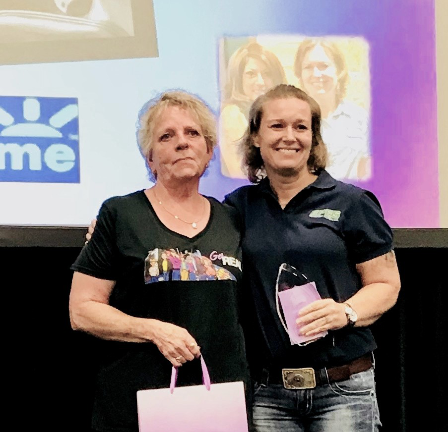 Trucker Elizabeth Sweet (pictured, right) accepting a special Queen of the Road award during Real Women in Trucking’s Saturday, Aug. 24, ceremony at GATS. She is pictured with award presenter Michelle Scolari, among award honorees in the current earlier-year round of this year’s Queen of the Road program. Read more about Scolari and fellow earlier honorees Audrey White and Ramona Hogue via this link.