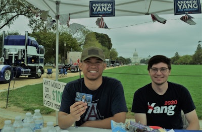 Alex Aquilod (left) and Mike Perola, representatives of the Andrew Yang Democratic presidential campaign, are set up amid the bobtails parked along the wide walking paths on the mall. Yang’s platform urges a novel approach to displacement of employment by automation. He is virtually alone among presidential candidates in having any focus whatsoever on trucking. His approach is not to slow such tech advancements down but rather attempt to empower those across sectors who become victims of it. One central element of the platform: an idea for a $1,000 baseline income for all U.S. citizens.