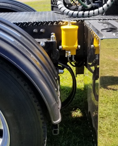 The yellow canister, shown here on the frame rail ahead of Rice’s passenger-side drive tires, houses the oil filtration media in the Clean Air Fleet system.