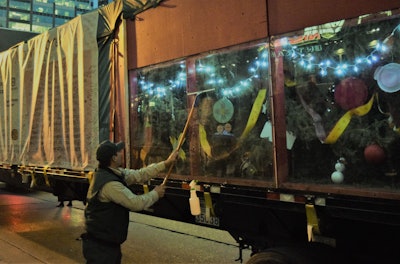 Ricardo Leon of the U.S. Forest Service, based near where this year’s Capitol Christmas Tree was harvested in New Mexico’s Carson National Forest, squeegeed view windows onto the tree’s top at the rear of the trailer ahead of events outside the public entrance to Bridgestone Arena November 21 in Nashville.