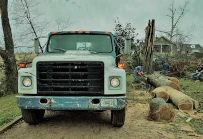 Kohler said he was on his way toward another tree in the area he was planning to purchase from the owner of the property. He couldn’t make the turn in the road at the top of my friend’s driveway without moving some of the debris lining the road out of the way, so he proceeded to start doing that with the loader; then he noticed the quandary the guys on hand were in with the remaining large trunks.