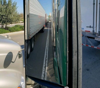 This picture from the Quality Transport driver described in the article shows the long line of trucks awaiting to unload at a Costco distribution center in California last week.