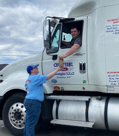 Logan Miller handing up a sack lunch to his father, Jason.