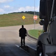 Man standing in open service area in front of semi truck