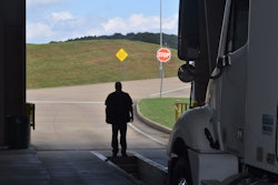 Man standing in open service area in front of semi truck