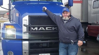 Anthony Townley Sr. standing in front of a blue Mack semi-truck