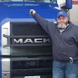 Anthony Townley Sr. standing in front of a blue Mack semi-truck