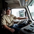 Truck driver in cab of semi-truck