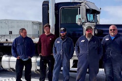 team photo taken outside of 1980 Kenworth W900A