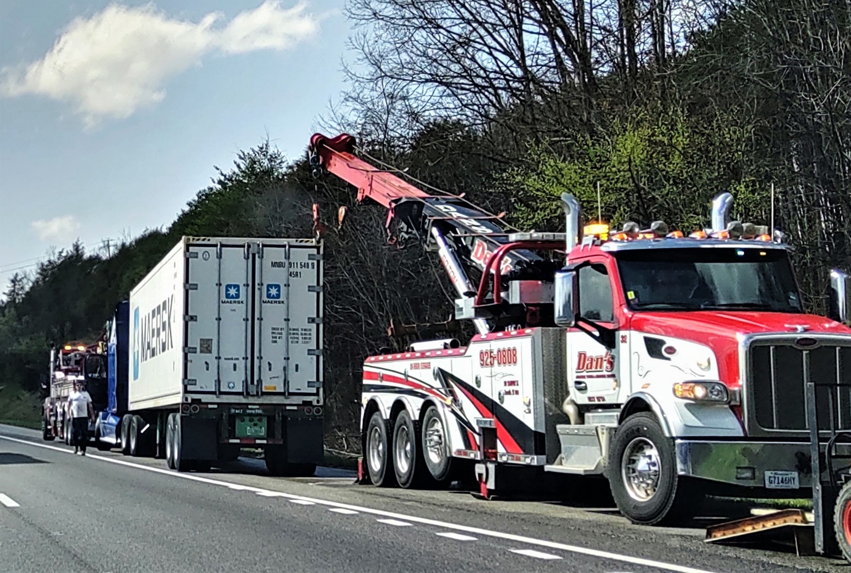 Tow rig parked on shoulder of road with semi-truck