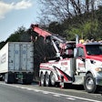 Tow rig parked on shoulder of road with semi-truck
