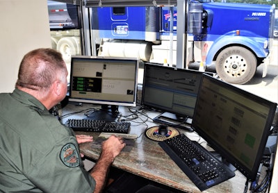 Trooper at computer watching truck cross scales inspections