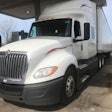 white semi truck parked getting fuel