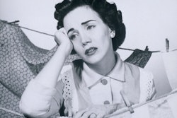 a woman resting her elbow on a clothesline with a sad face