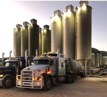 semi trucks parked out front of an oil site