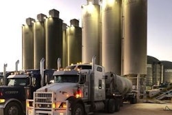 semi trucks parked out front of an oil site