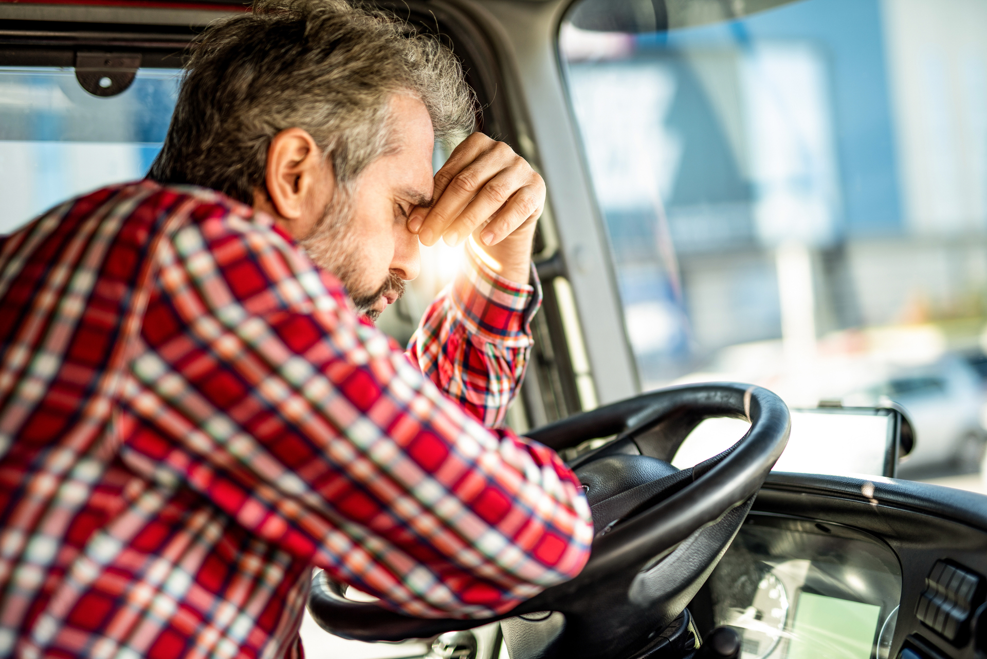 upset trucker leaning on steering wheel