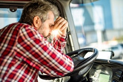 upset trucker leaning on steering wheel
