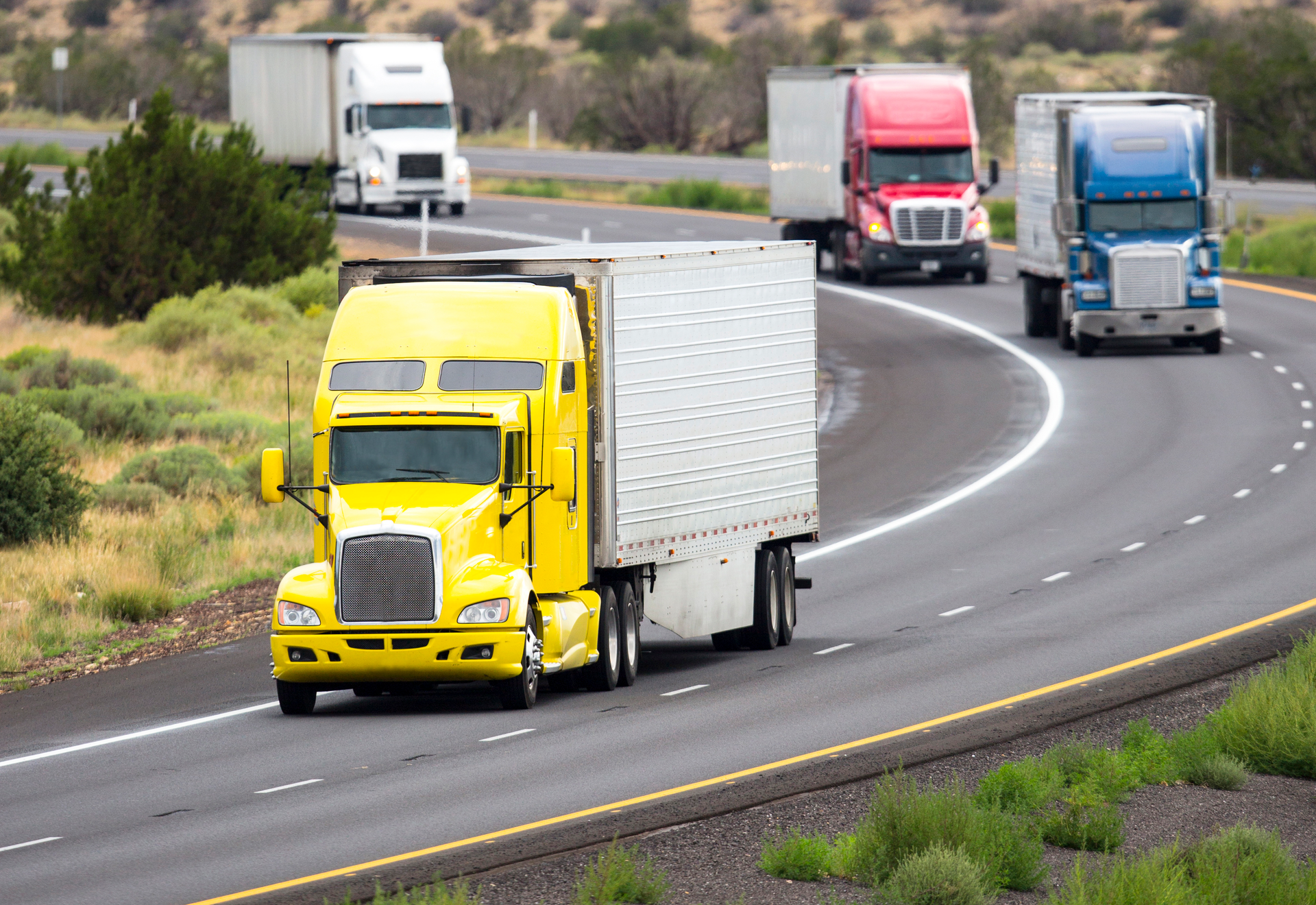 Four trucks driving on highway