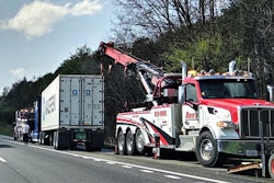 semi truck and tow truck on shoulder