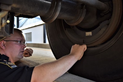 man performing brake inspection