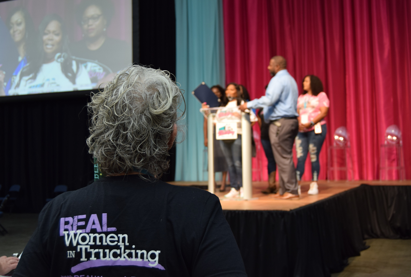 Idella Hansen here looks on near the beginning of the program as Sharae Moore welcomed attendees. Hansen was among several representatives on hand with Real Women in Trucking, whom Moore thanked during her opening remarks.