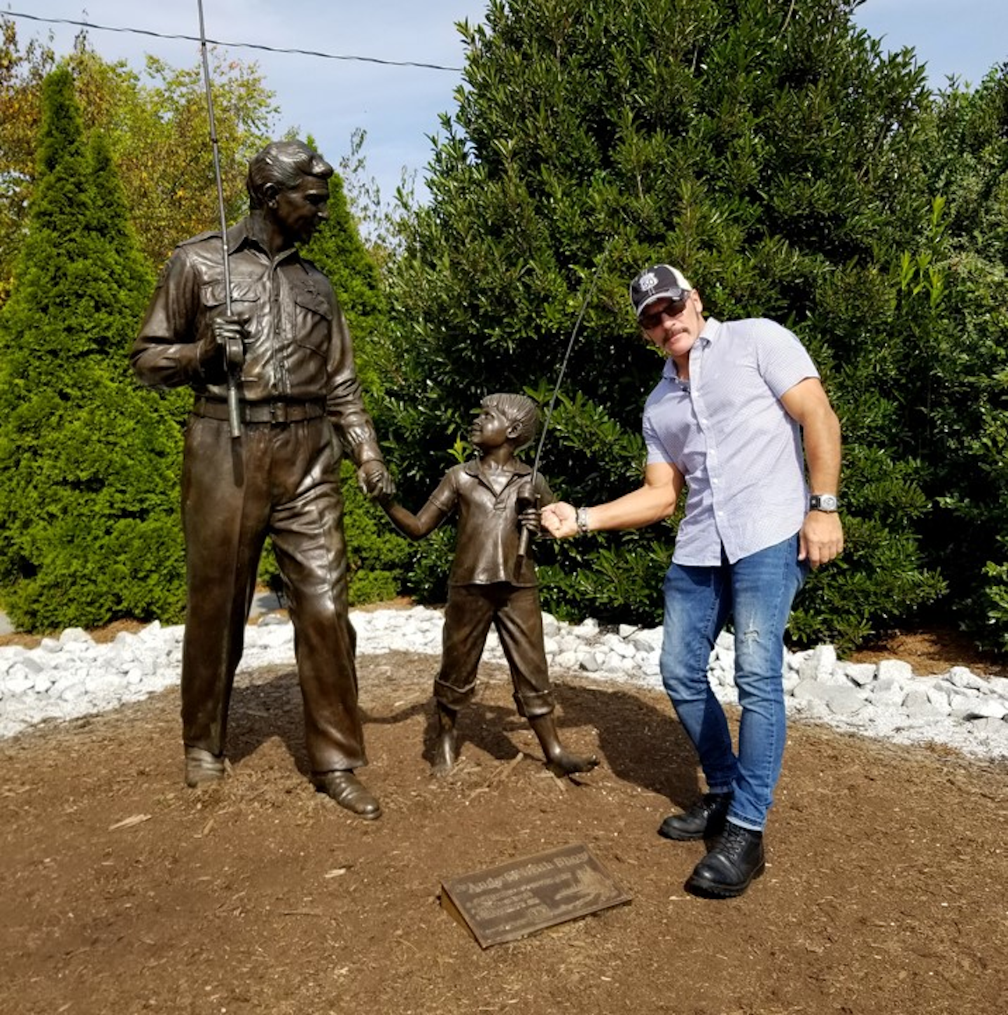 The author of this story, Robb Mariani, poses here with statues of Griffith as Andy Taylor and his son, Opie, played in 'The Andy Griffith Show' by Ron Howard.