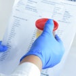 gloved hands holding a urine sample and drug test results