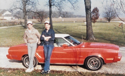 W. Joel Baker pictured with a friend by an old Ford Mustang on break from military training in the 1980s