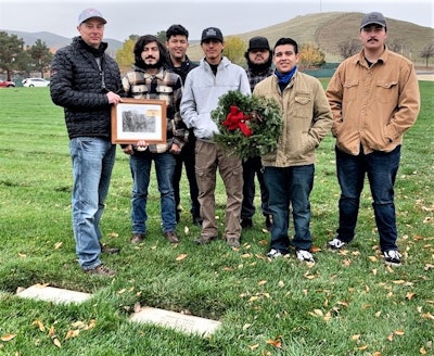 Dave Dein and students holding a picture of Philip Dein and a wreath