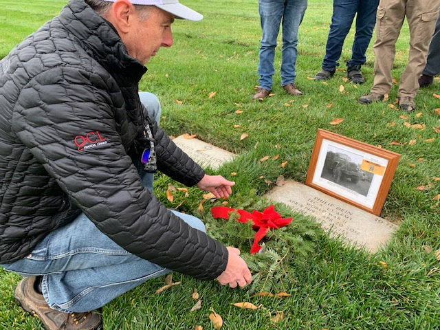 Dave Dein laying wreath on father Philip Dein's grave