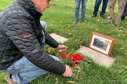 Dave Dein laying wreath on father Philip Dein's grave