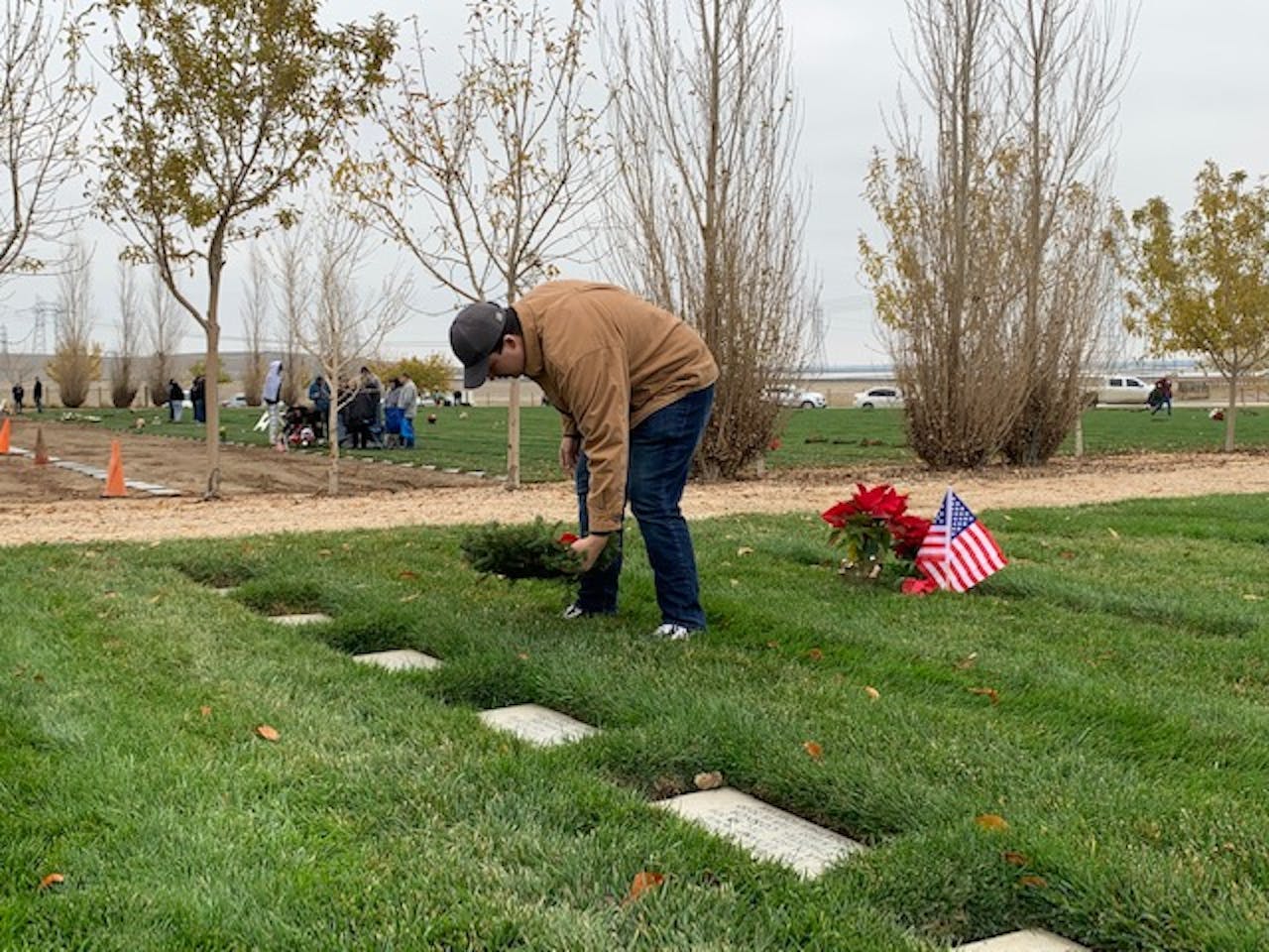 One among Dein's current and former students laying a wreath this past Saturday. Tradition among Wreaths volunteers is to speak the name of the military veteran when laying the wreath.