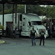 Driver couple walking back to the truck after meal purchase in truck stop
