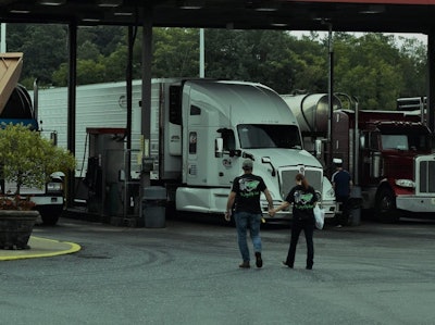 Driver couple walking back to the truck after meal purchase in truck stop