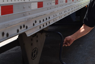 Person raising the landing gear of a trailer