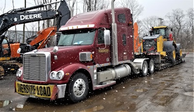 John Deere equipment being hauled on truck trailer