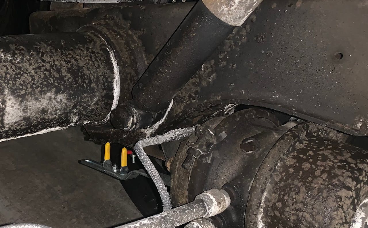 As is perhaps more apparent from this view, reading stroke compliance visually with the device is a matter of viewing the indicators from the correct angle -- straight on (at a position perpendicular to) the yellow 'goalposts' as Stoll put it. As is evident in this picture, those posts are offset from the red indicator itself, which is attached directly to the pushrod.