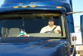 driver in cab of truck in sunlight