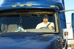driver in cab of truck in sunlight