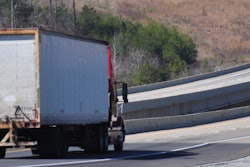 Tractor-trailer on the highway, approaching a bridge