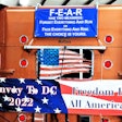 Banners featured on the back of owner-operator Ruben Carrion's well-known custom 2000 Peterbilt 379. The picture was taken at Ted Everett Farm Equipment, where the People's Convoy gathered for a day off from movement on Wednesday.