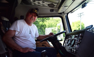 Howard Salmon between the wheel of his truck