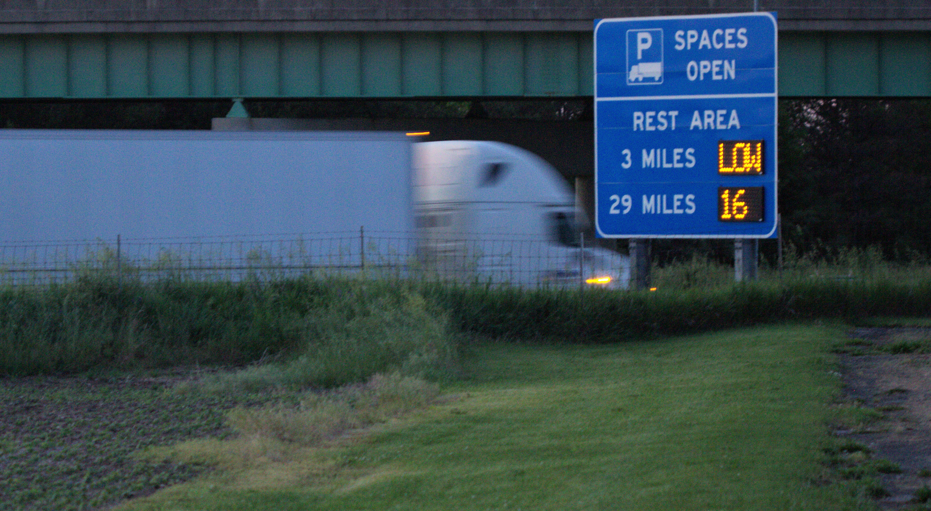 Truck with rest area parking availability sign