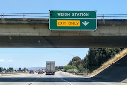 Truck headed past weigh station sign to Gilroy scale on SB 101 in California