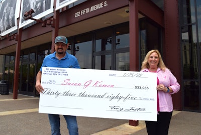 Tony Justice presents a large check for $33000 to Karin Moughler of Susan G. Komen foundation