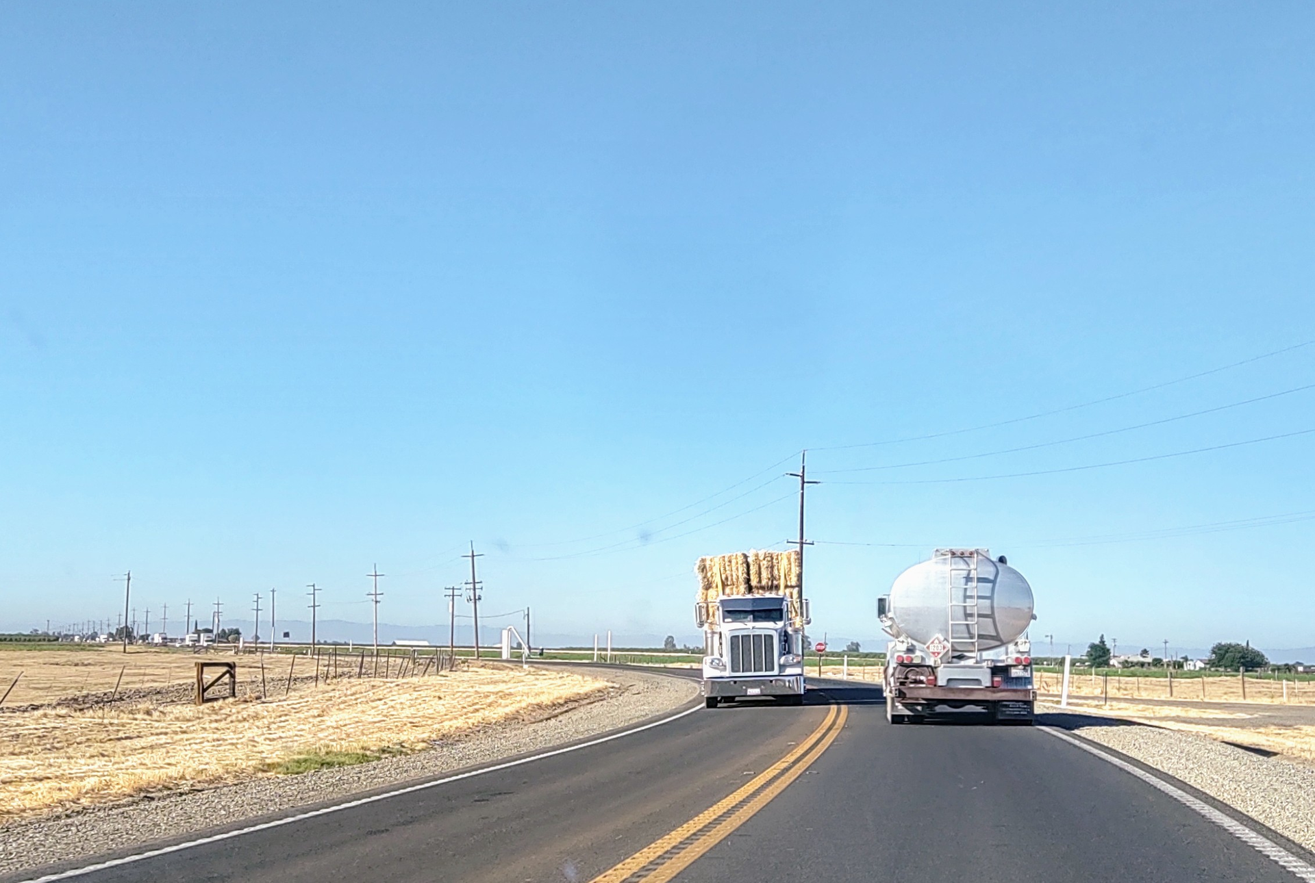 Tanker and hay hauler on highway
